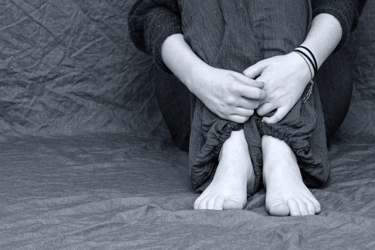 Anxious person holding legs