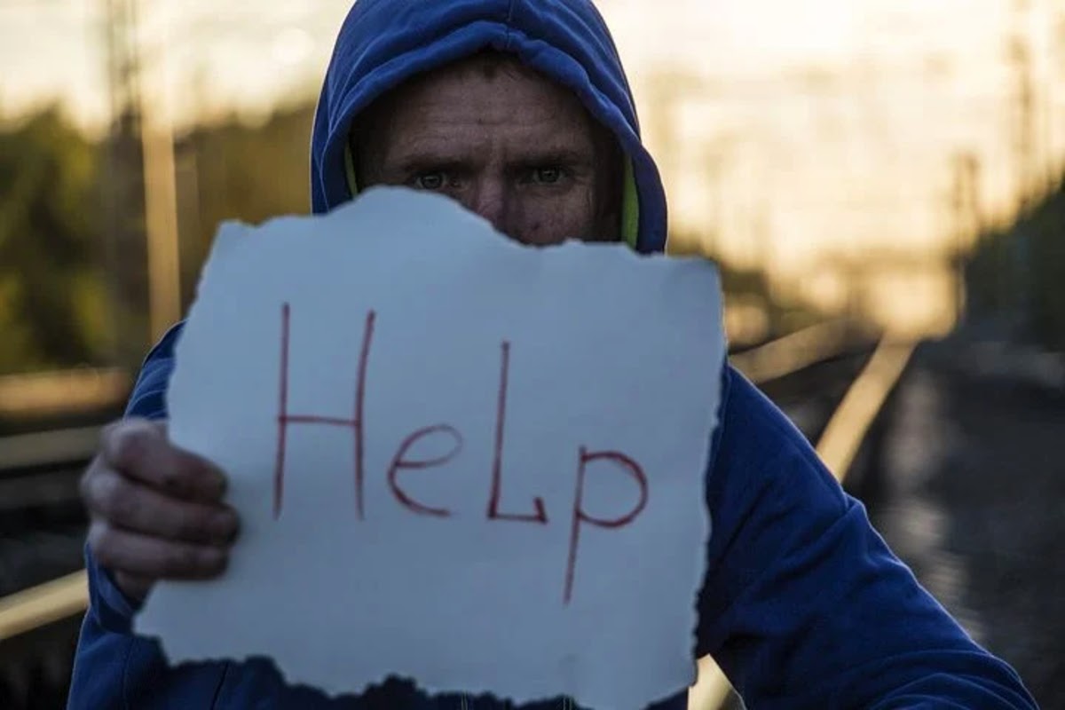 person holding up sign that says help