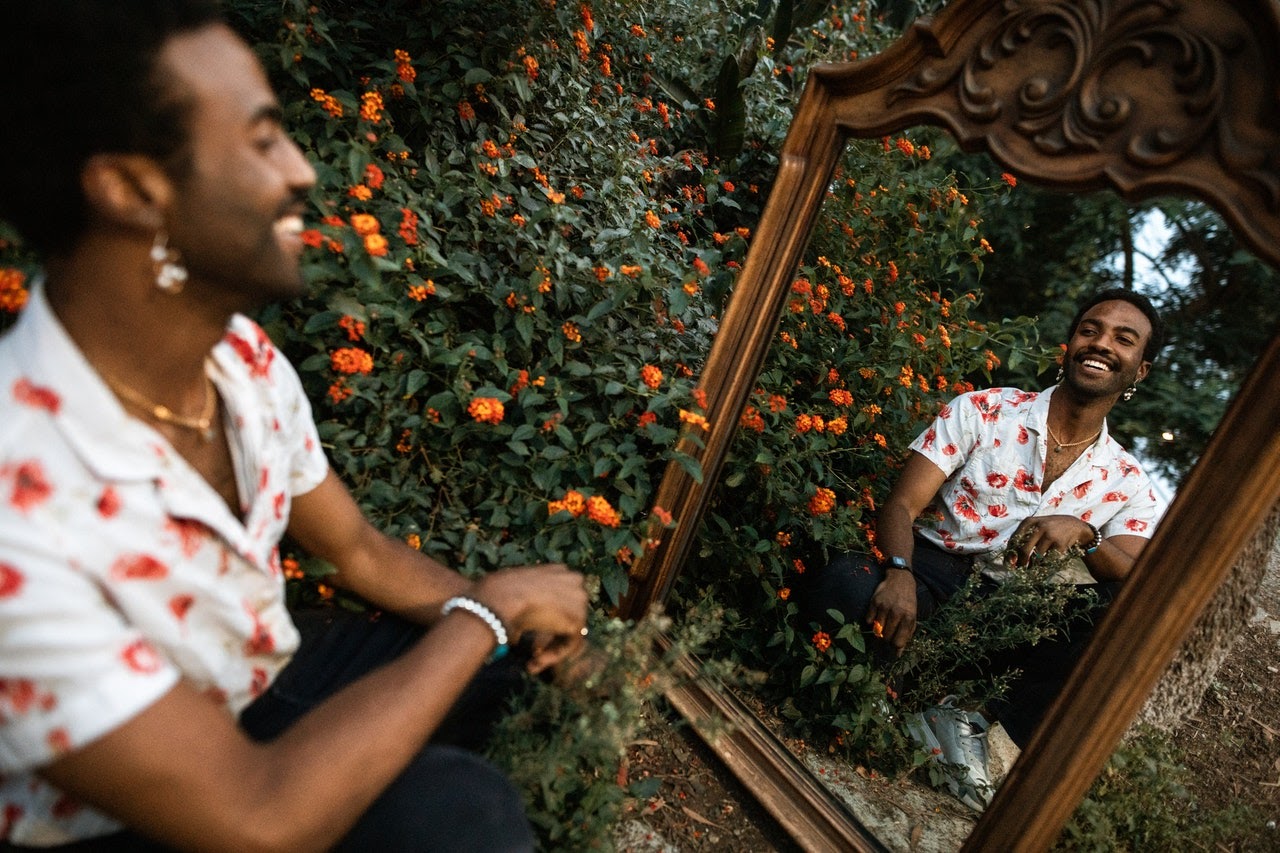 Man smiling at his reflection in a mirror