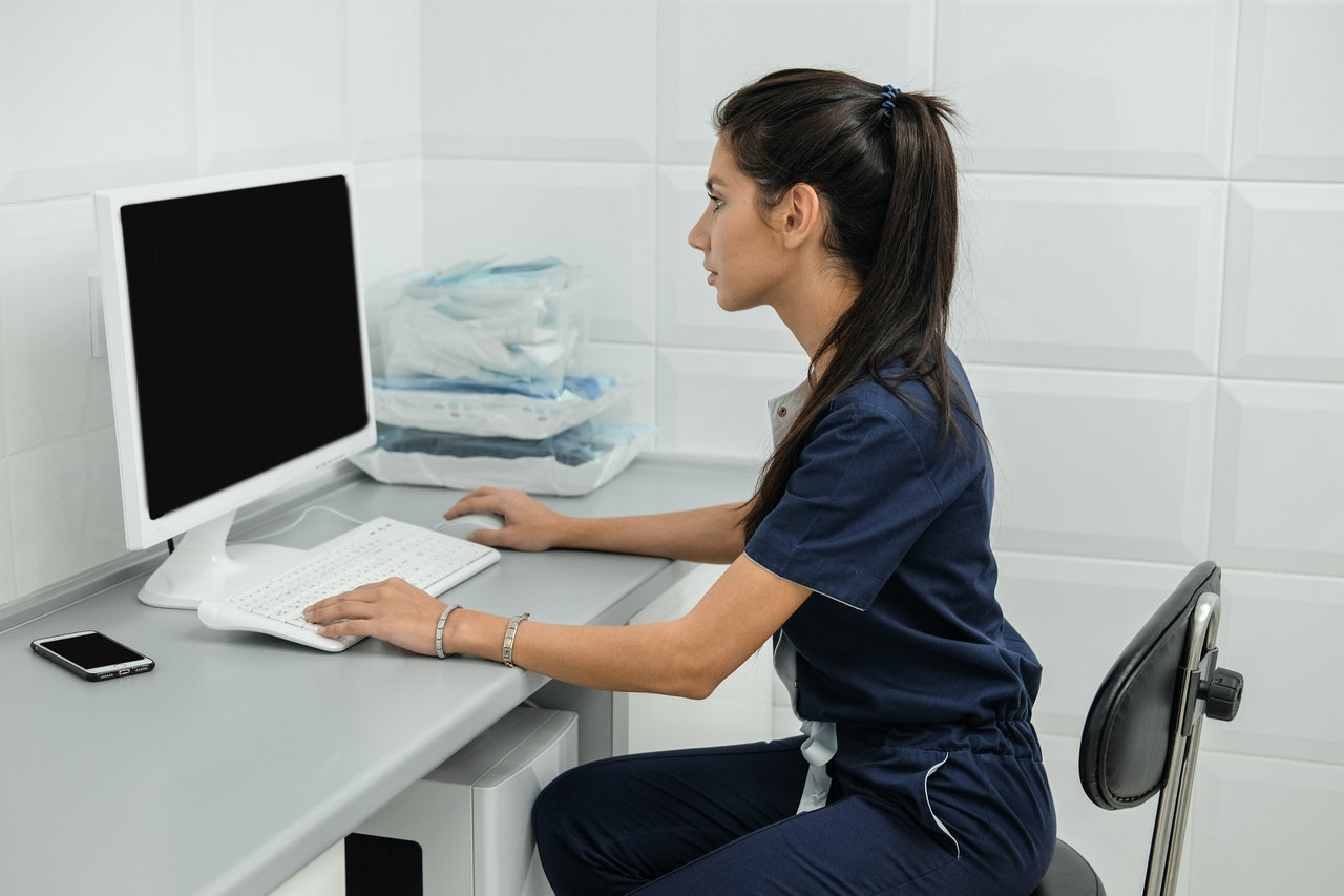 TMS technician sits at desk and works on desktop computer