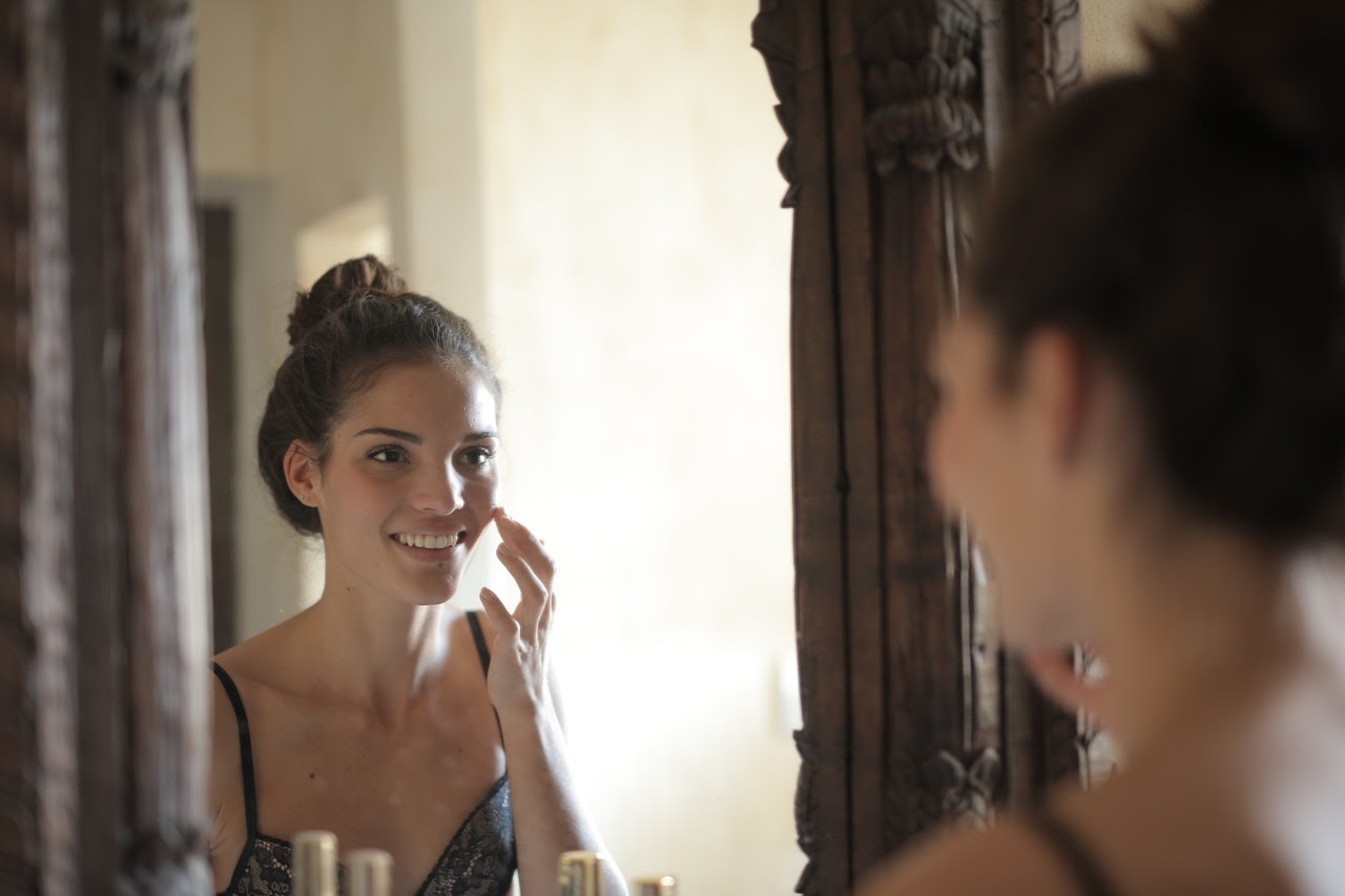 Woman smiles at her own reflection in the mirror