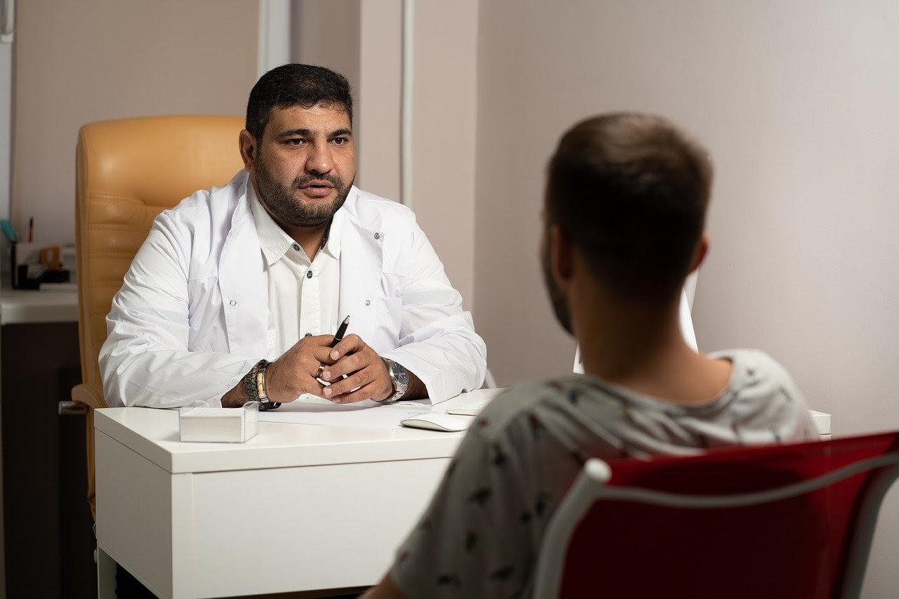 Psychiatrist talks to a client while sitting at his desk