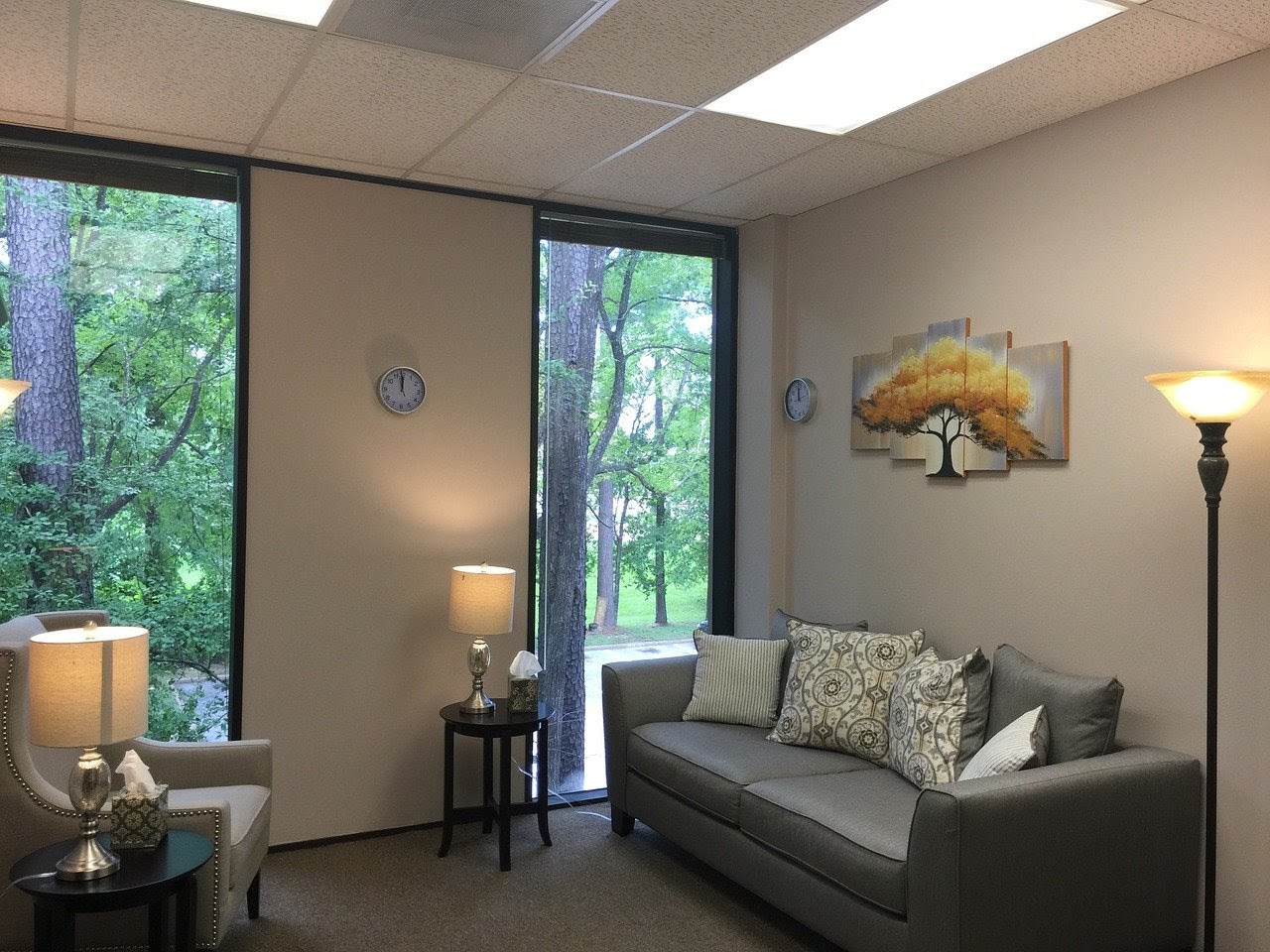 Substance abuse counselor's office with a couch, chair, and lamps lighting up the room