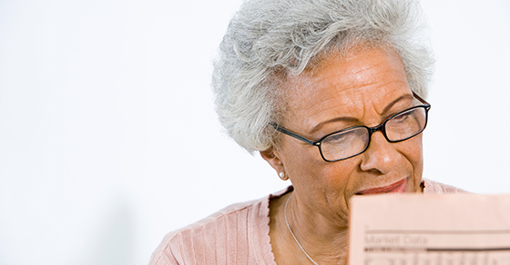 senior woman looking at stock pages in newspaper