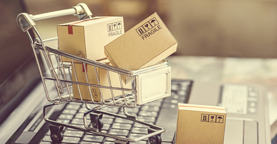 tiny shopping cart full of boxes on computer keyboard