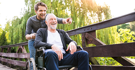 younger man pushing an older man in a wheelchair