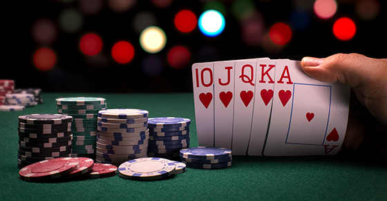 stacks of poker chips and cards with a royal straight flush