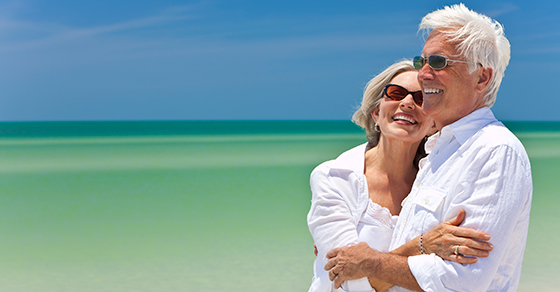 senior couple smiling at beach