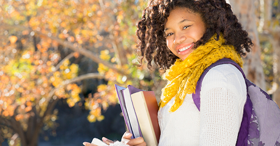 young woman with backpack and books