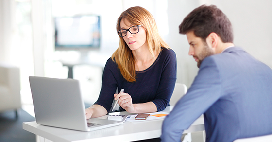 woman and man looking at financials on laptop