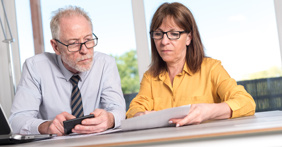 man and woman looking at financials