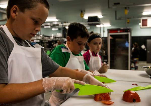 kids learning to chop tomatoes