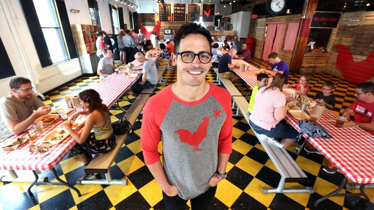 Hot Chicken Takeover owner Joe DeLoss standing and smiling in resaurant