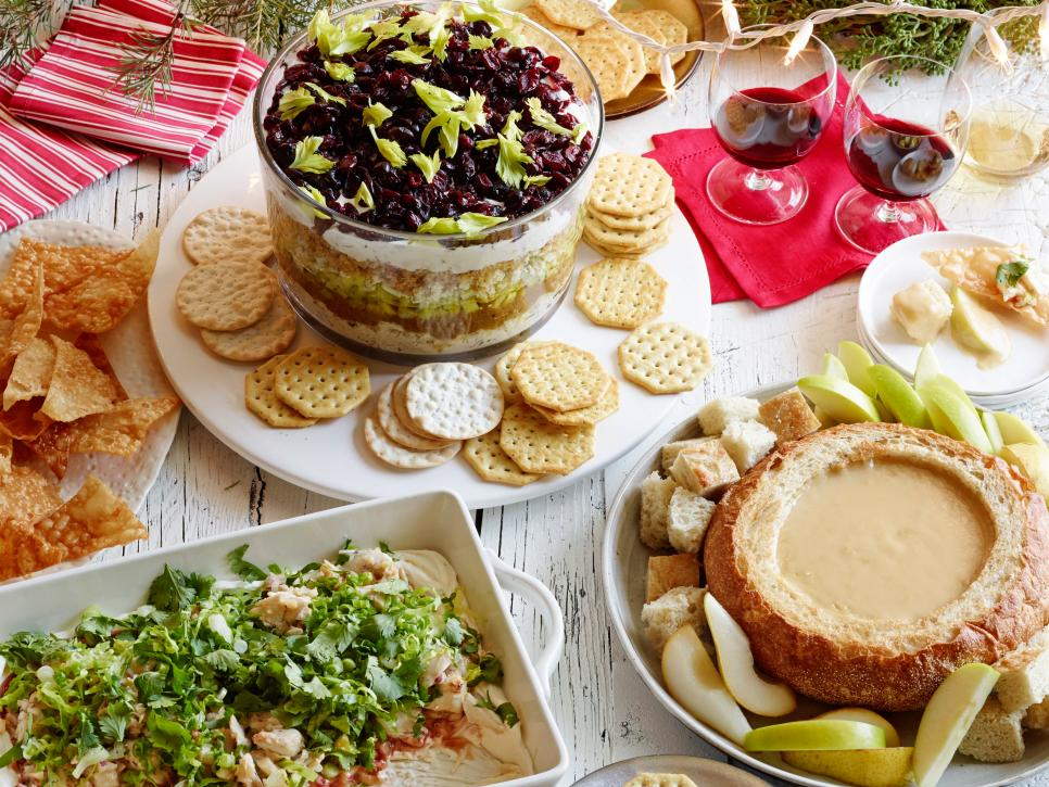 table of snacks including crackers, chips, salad, and fruit