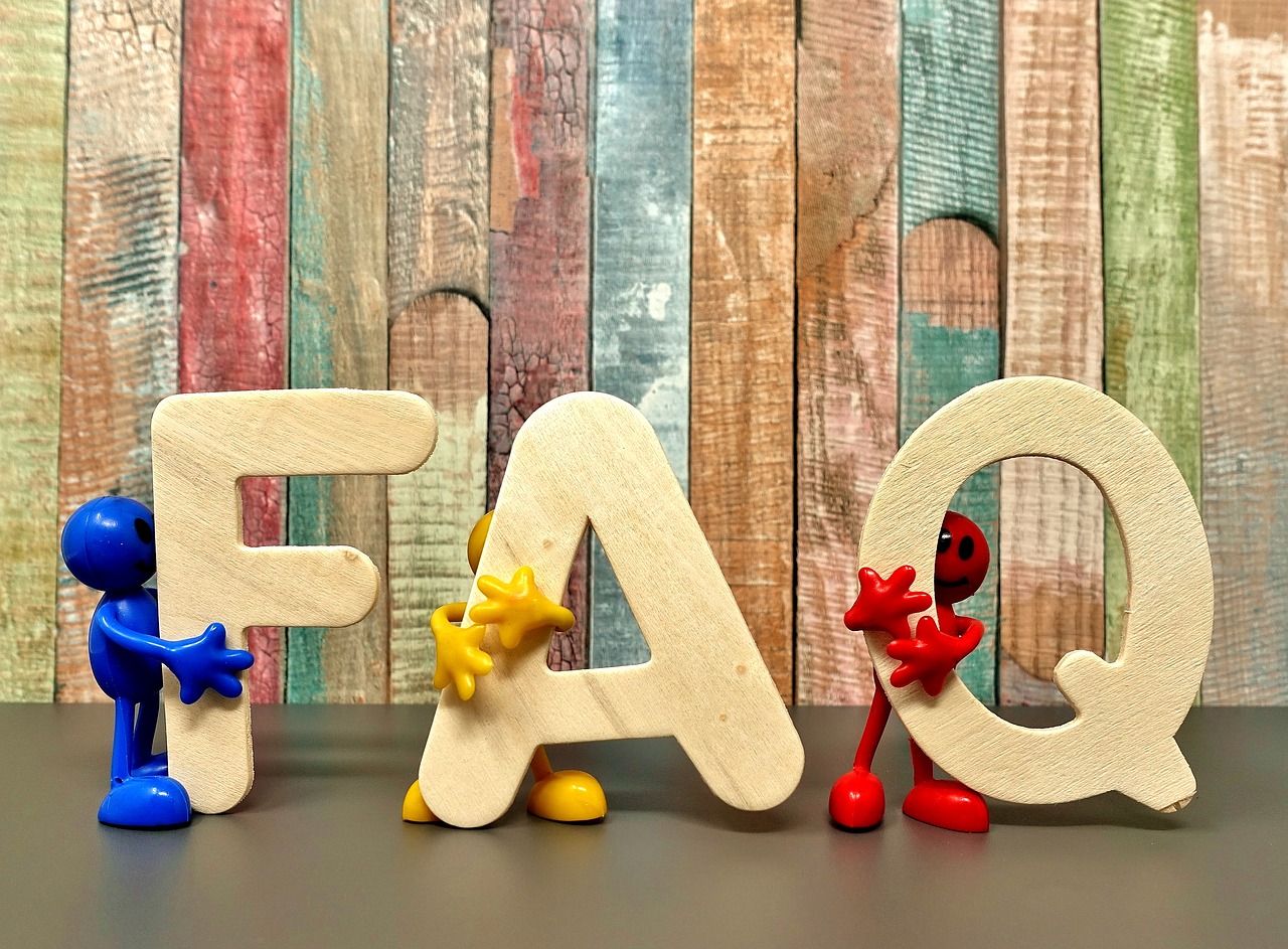 Three little figures -- one blue, one yellow, and one red -- each hold a wooden letter, F, A, and Q, respectively.