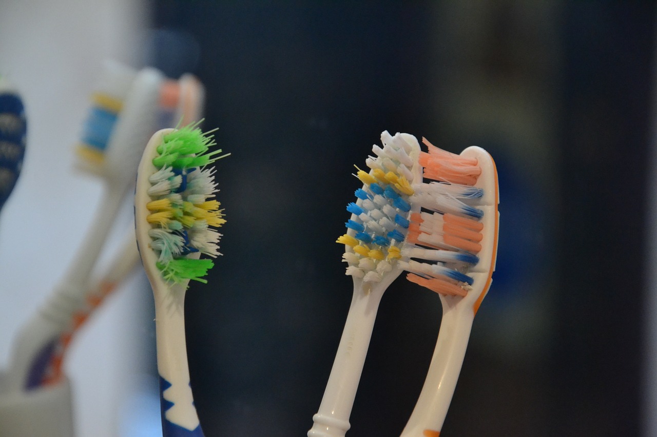 Three soft bristle toothbrushes that look used and worn