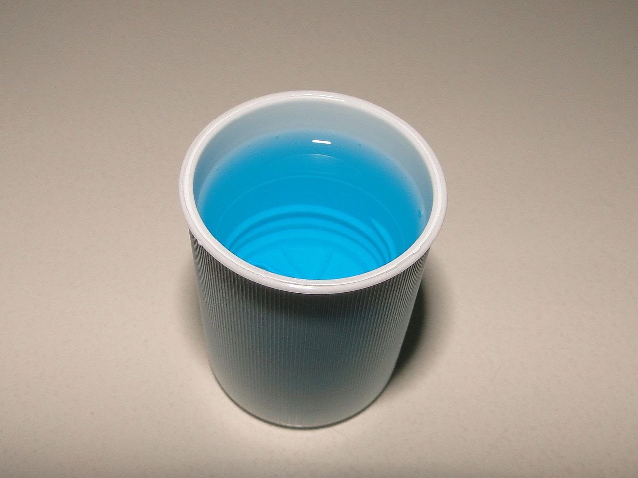 A cup of mouthwash sits waiting to be used.