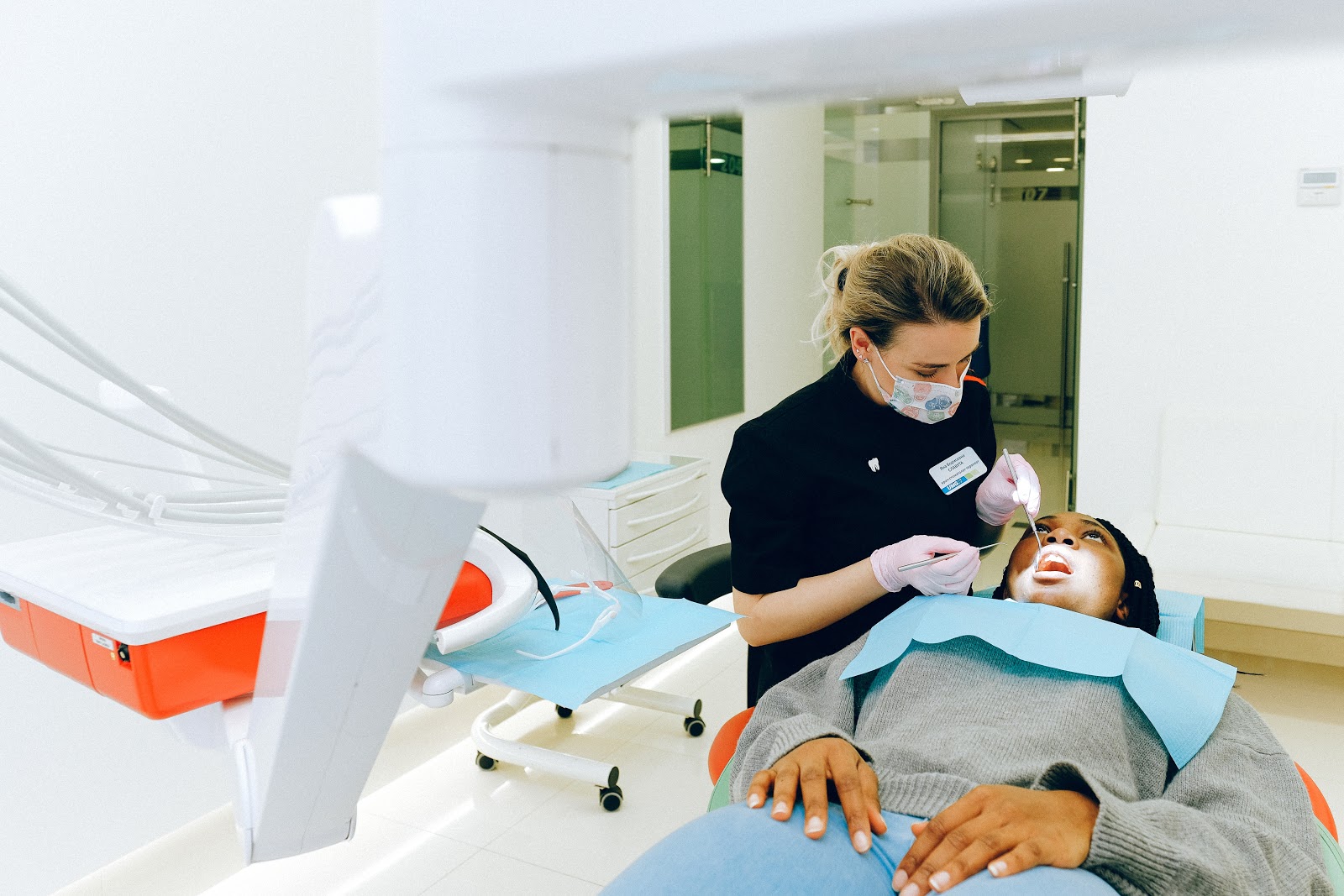 Lady sitting in a dental chair with a dentist working on her mouth