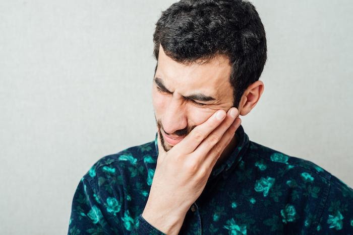 Man in pain holding his jaw