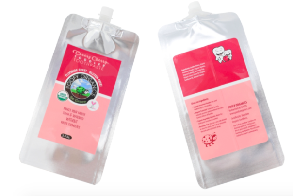The front and back of a packet of cherry flavored kids' toothpaste from Poofy Organics