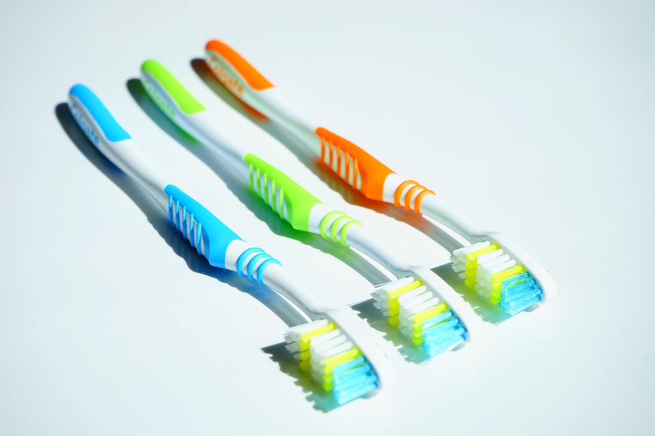 Three toothbrushes sit on a table.