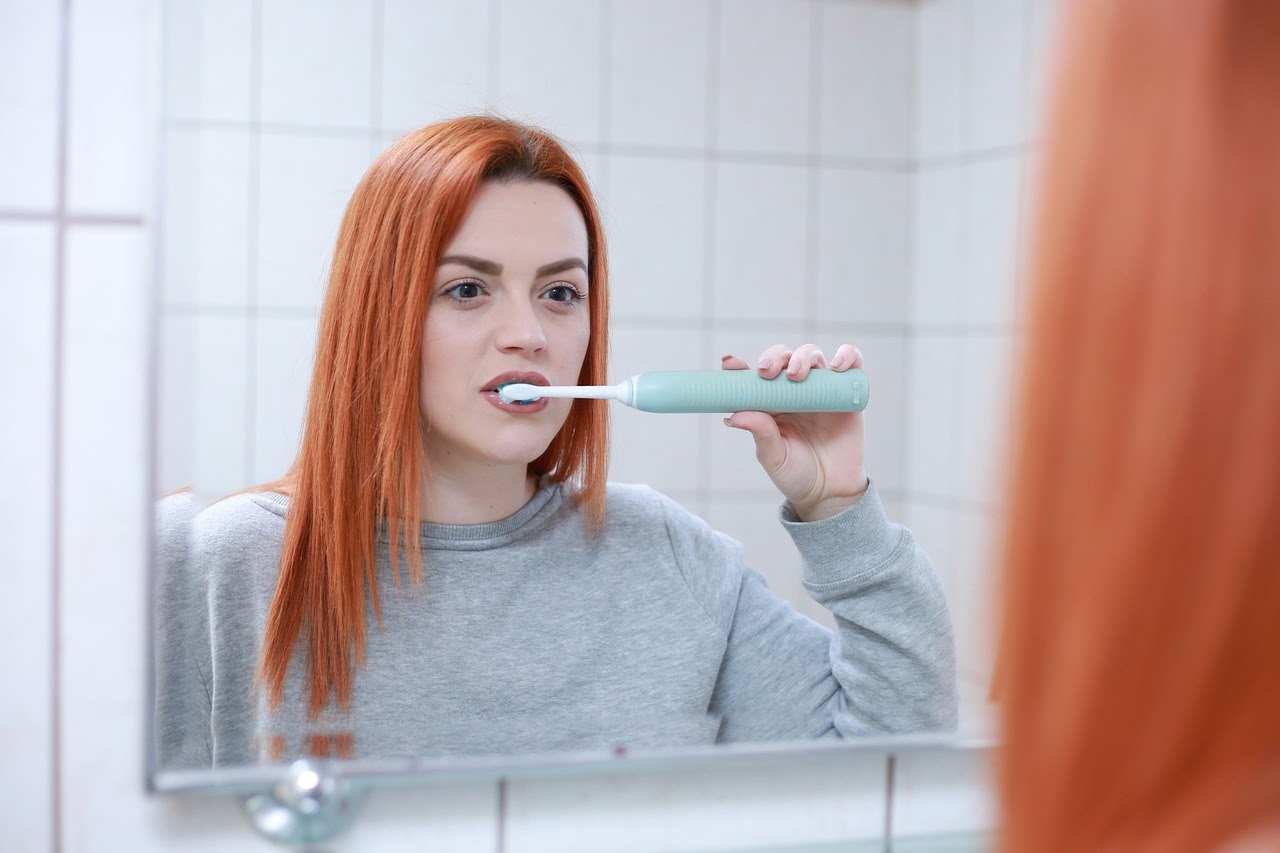 A woman brushes her teeth correctly.