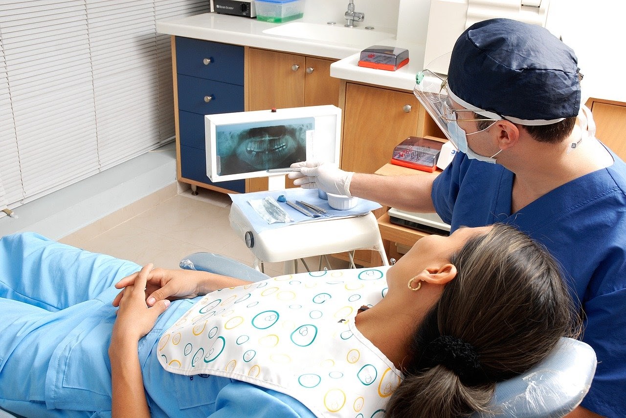 A woman looks at her mouth x rays with her dentist and learns about the health of her teeth.