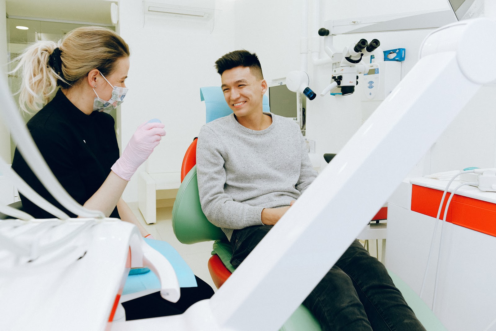 A man talks to his dentist about what kind of mouthwash she recommends for his mouth.