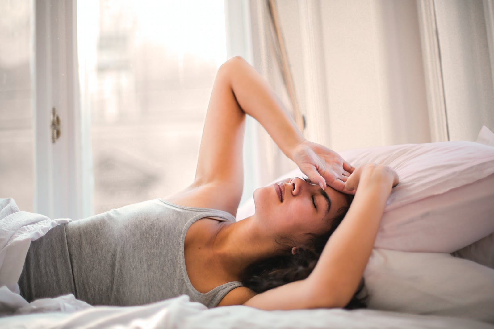 A woman lays in bed, unable to sleep.