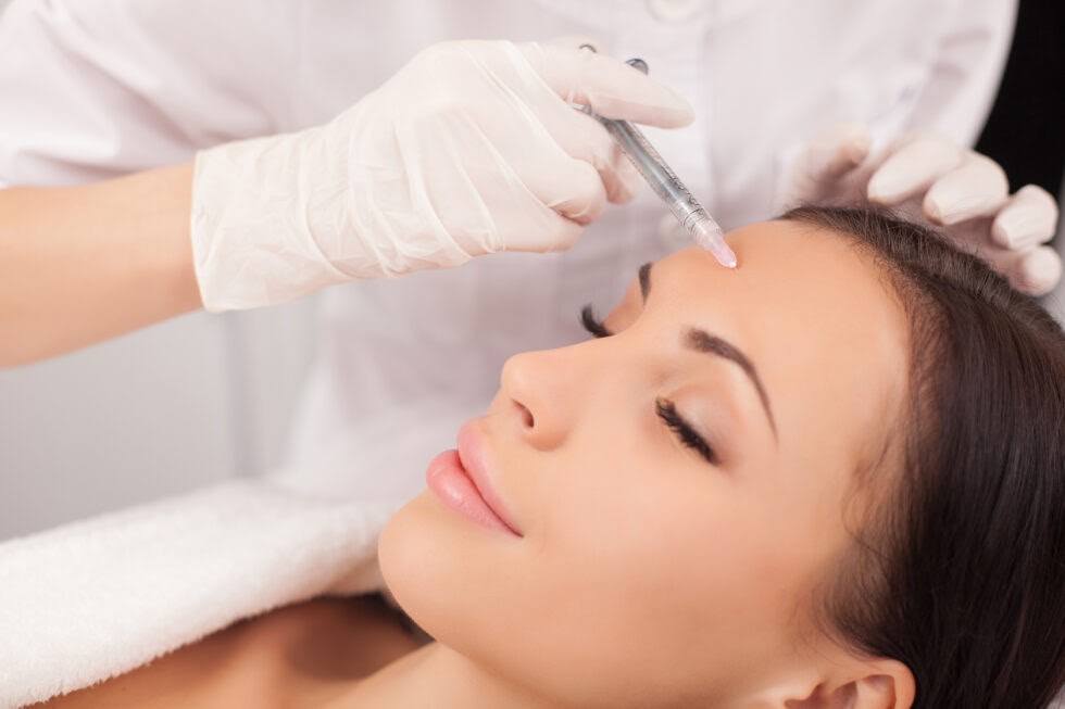 woman getting botox injected into her forehead to prevent wrinkles