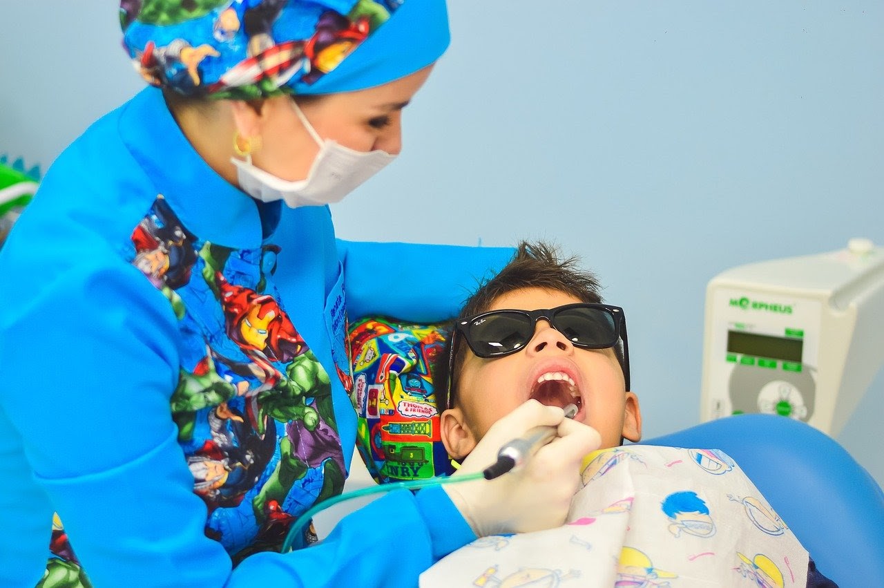 a child gets his teeth cleaned by his dentist