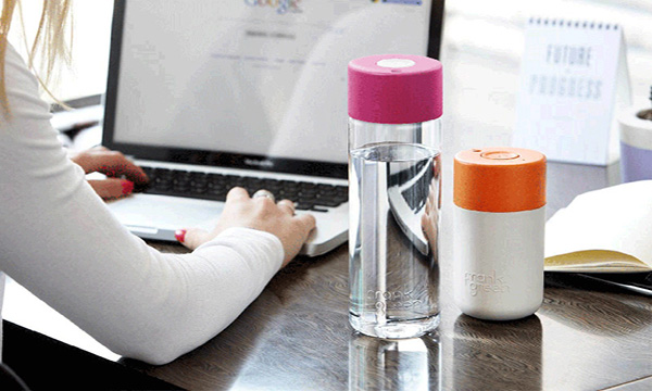 image of woman working on laptop with water bottles next to her.