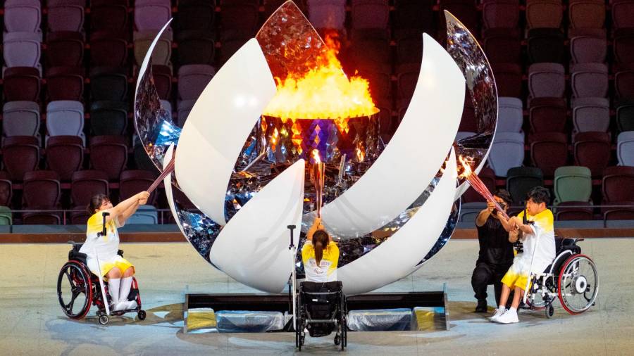 Los deportistas Yui Kamiji, Shunsuke Uchida y Karin Morisaki encienden a la vez la antorcha olímpica. Los tres van en silla de ruedas y cada uno de ellos está colocado en un lateral de la gran esfera.