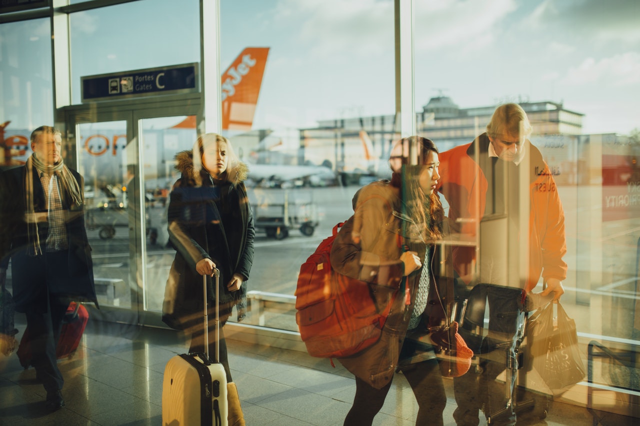 People walking in an airport terminal getting ready to board a flight