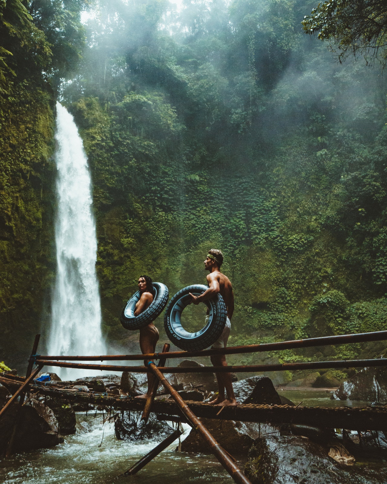 couple exploring waterfall in lush green jungle