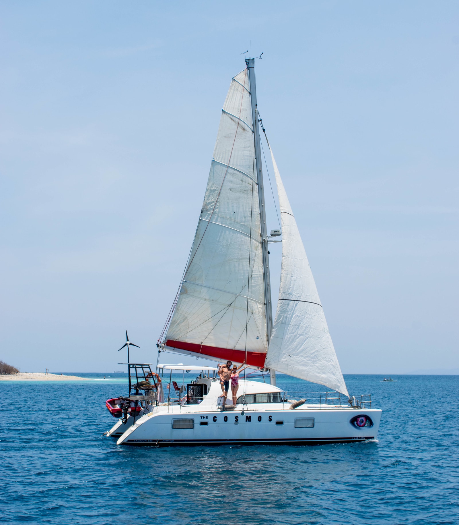 couple with child aboard their white sailboat