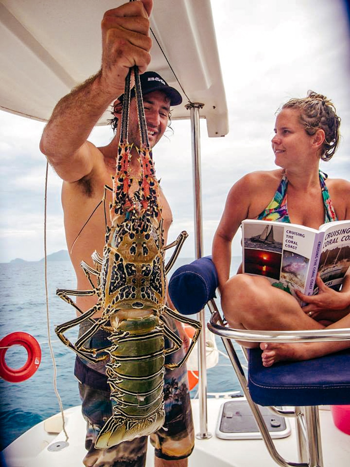 Man and woman on sailboat with freshly caught lobster