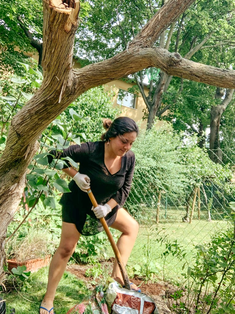 A female volunteer shoveling dirt in a garden in Vienna