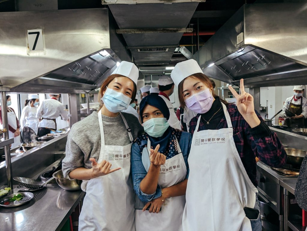 Students in Taipei taking a culinary class posing for the camera in the kitchen
