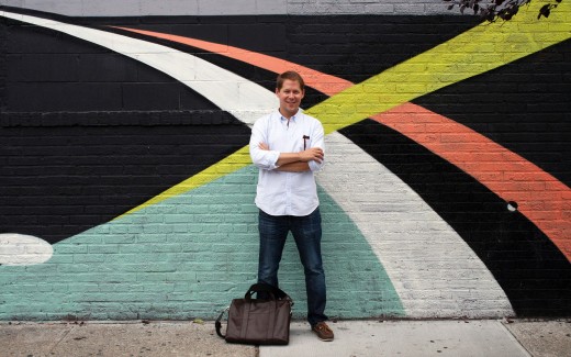 Founder of Sugarlift Wright Harvey standing in front of a mural in New York