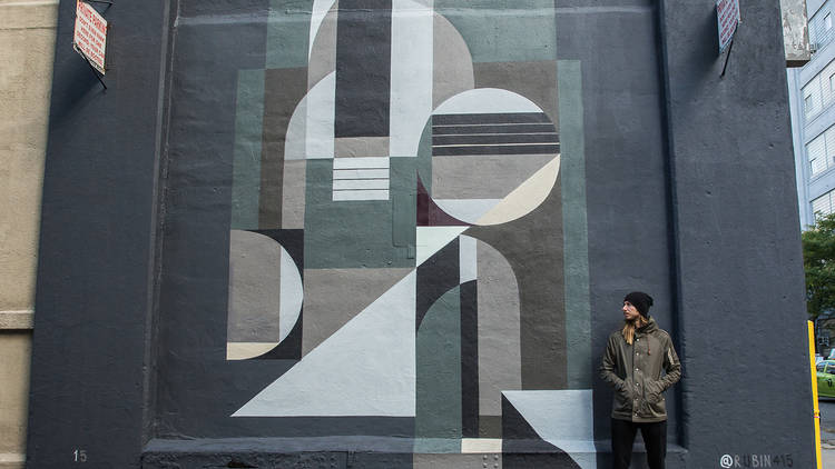 Sugarlift artist Rubin415 in front of one of his murals in New York
