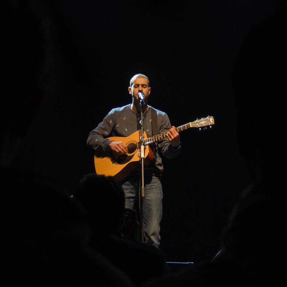 Denis Bustamante singing on stage