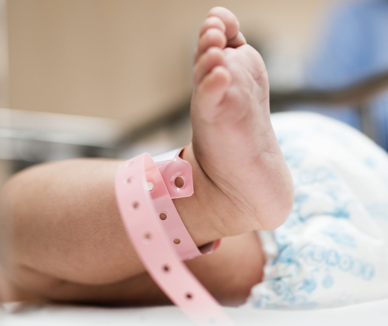 Baby's foot with hospital bracelet around ankle