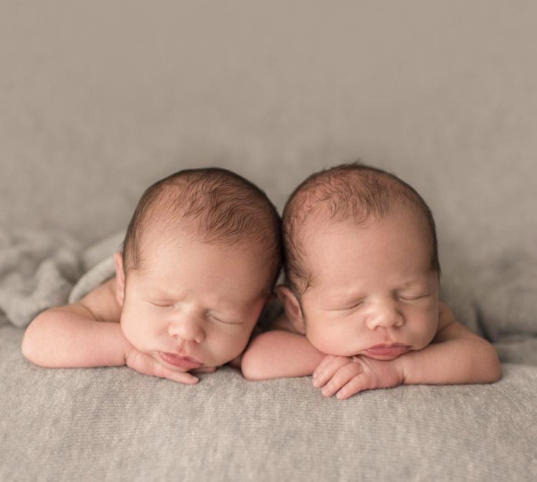 Set of twins sleeping with arms under their chin's