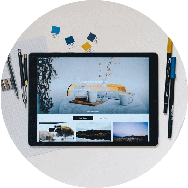 an ipad showing a photo editor web app with pens, markers and color palettes at the background