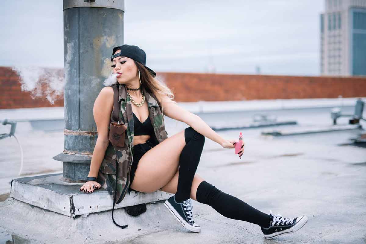 una modella viene ripresa mentre svapa su un tetto