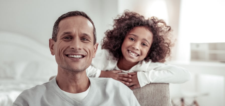 father and daughter sitting in chair smiling