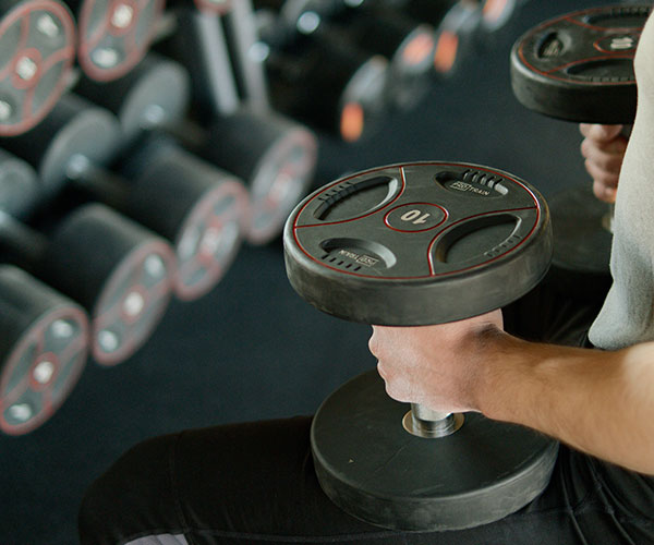 man-holding-black-dumbbells