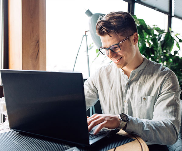 attractive-businessman-eyeglasses-working-laptop-typing-spending-time-cafe
