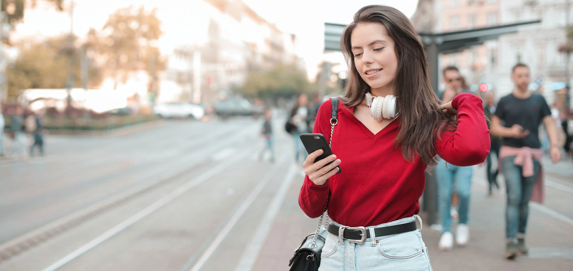 Woman using her phone on sidewalk